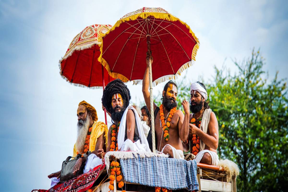 https://travelonica.com/wp-content/uploads/2024/09/10-INDKUMBH-india-sadus-festival-men-umbrellas-scaled-1.jpg