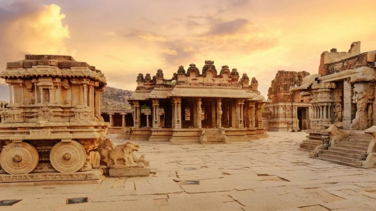 https://travelonica.com/wp-content/uploads/2024/09/antiguo-carro-de-piedra-con-ruinas-arqueologicas-en-el-patio-del-templo-vittala-en-hampi-karnataka-india-1280x720.jpg